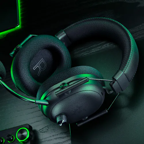 A close-up of the Razer Blackshark V3 Pro's left earcup, showing the large textured volume knob and microphone mute switch.